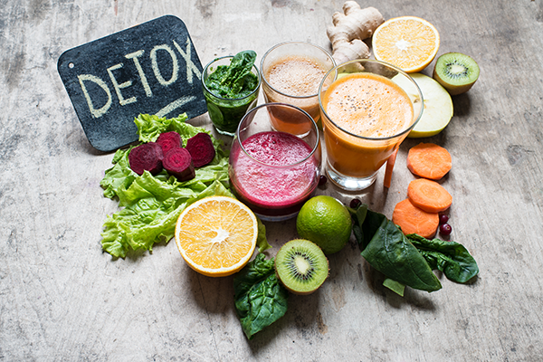 vegetables and juices in front of detox sign