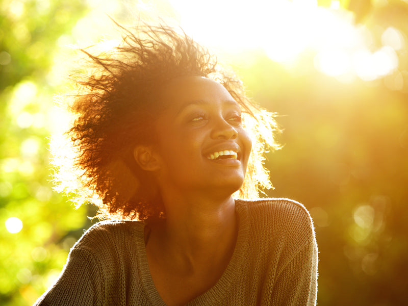 smiling woman, sitting in a bright outdoor setting