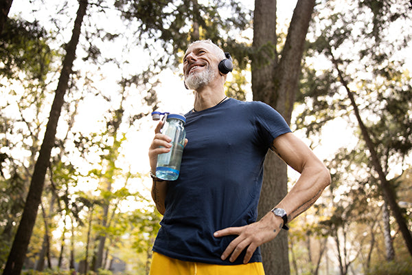 Man working out outdoors, smiling while listening to music