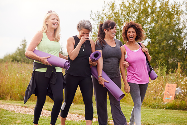 Women walking with exercise mats