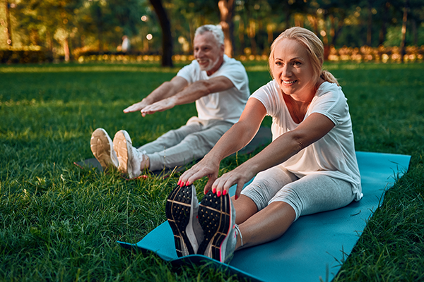 Elderly couple stretches to keep joints flexible