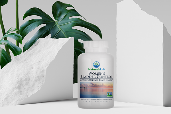 Women's bladder control bottle in front of monstera plant leaves and chalk