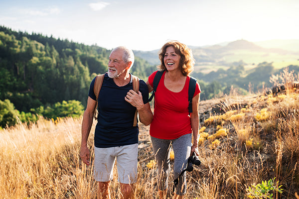Older couple hiking across a field