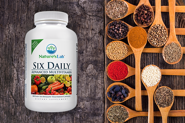 Six Daily Multivitamin on wooden table with spices and herbs