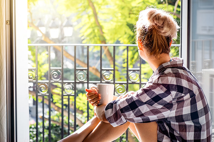 Woman drinking tea looking out a window