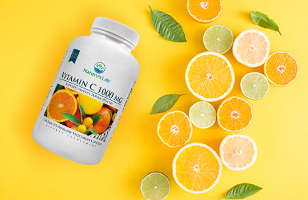 Nature's Lab Vitamin C supplement on orange background with citrus fruit